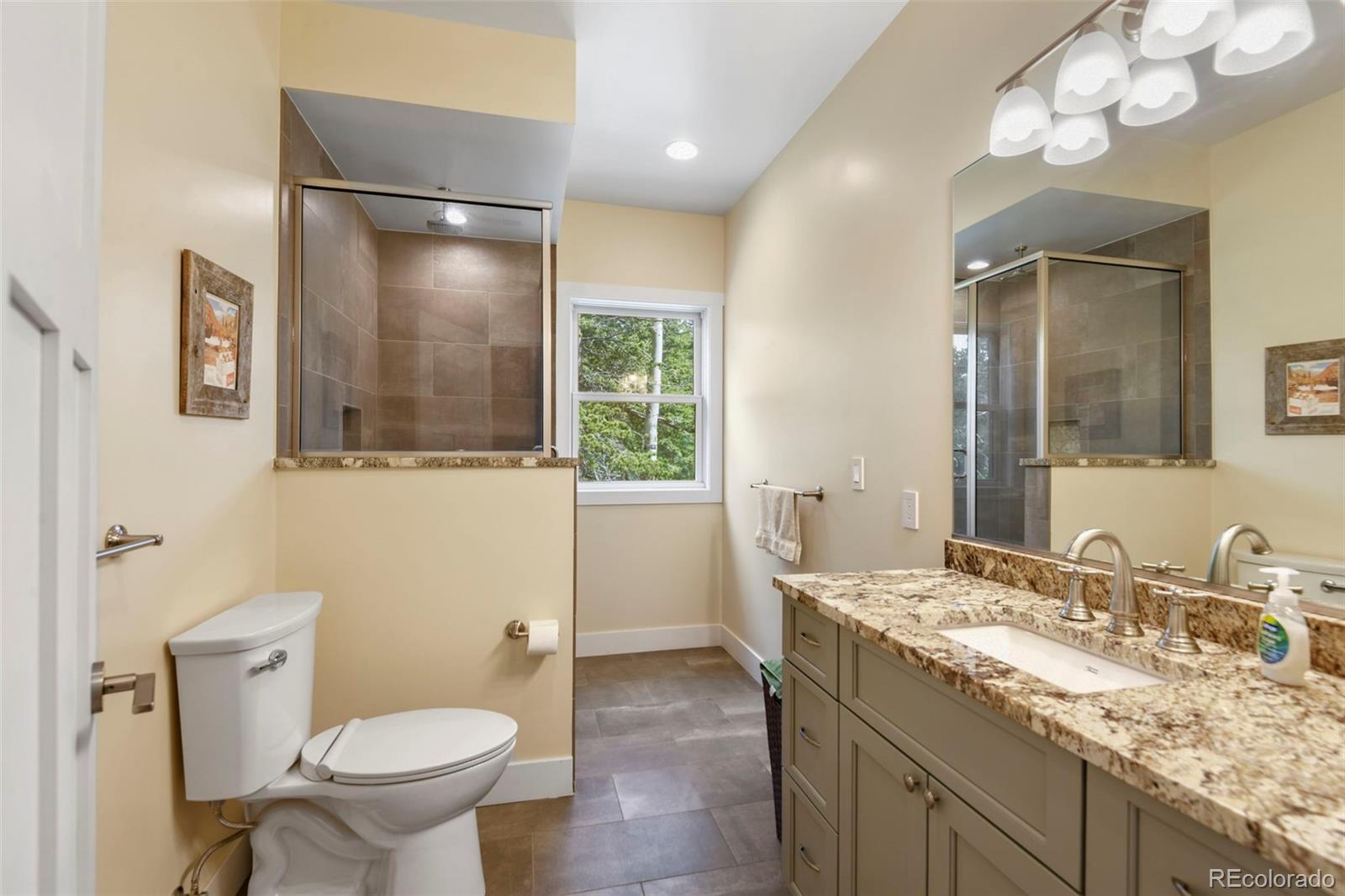 1555 Three Peaks Road Black Hawk, CO 80422 - Photo 33 of 50 a bathroom with a granite countertop sink toilet and shower