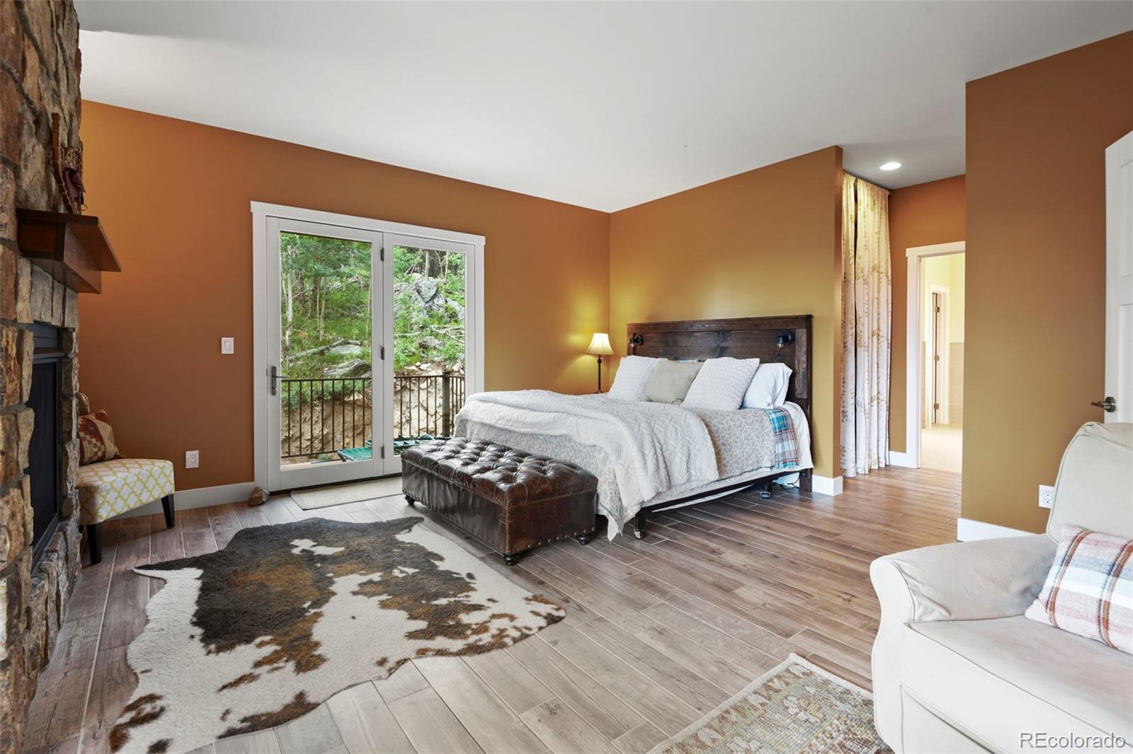 1555 Three Peaks Road Black Hawk, CO 80422 - Photo 37 of 50 a bedroom with a bed and wooden floor