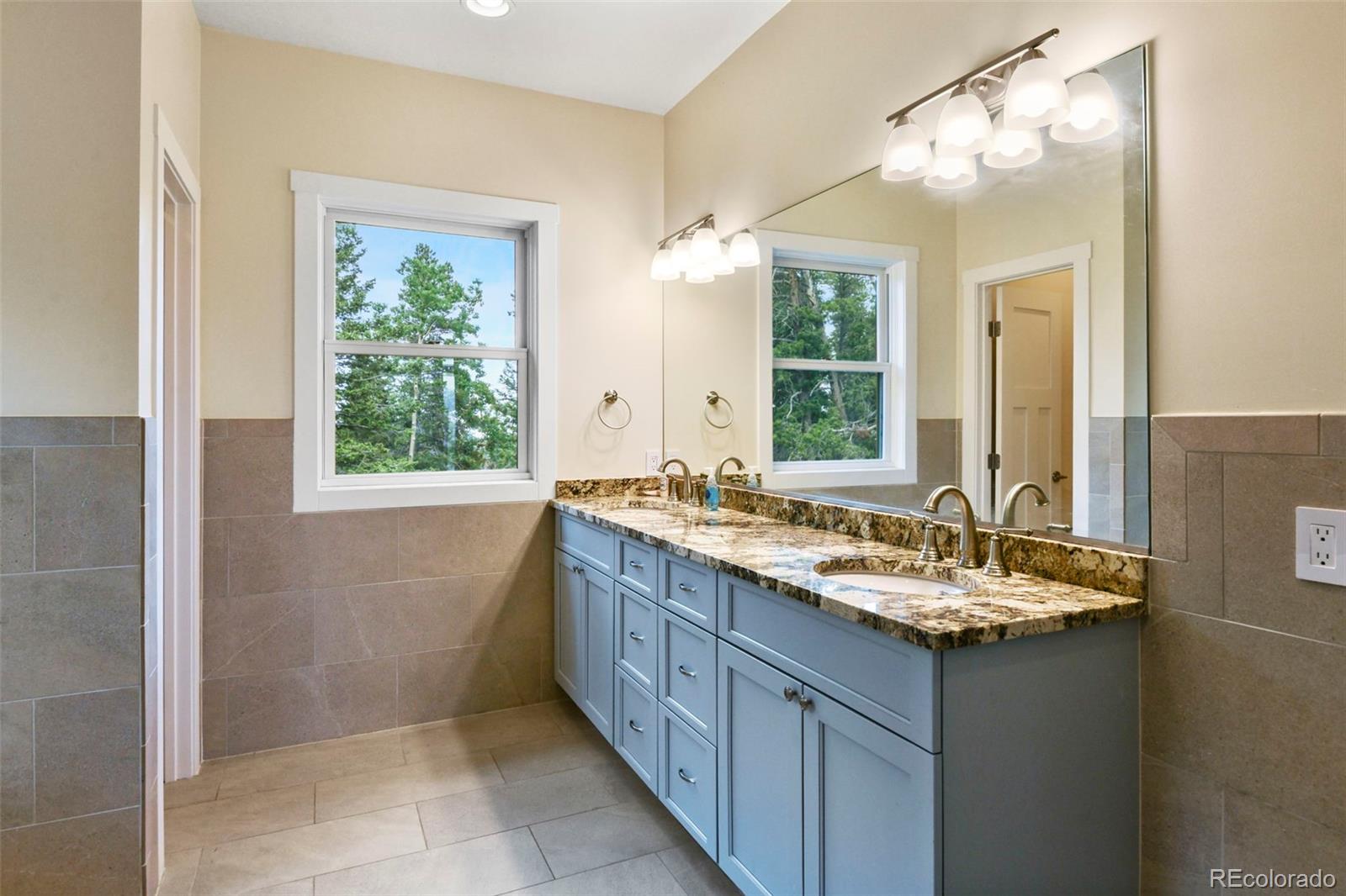 1555 Three Peaks Road Black Hawk, CO 80422 - Photo 43 of 50 a bathroom with a sink vanity and mirror