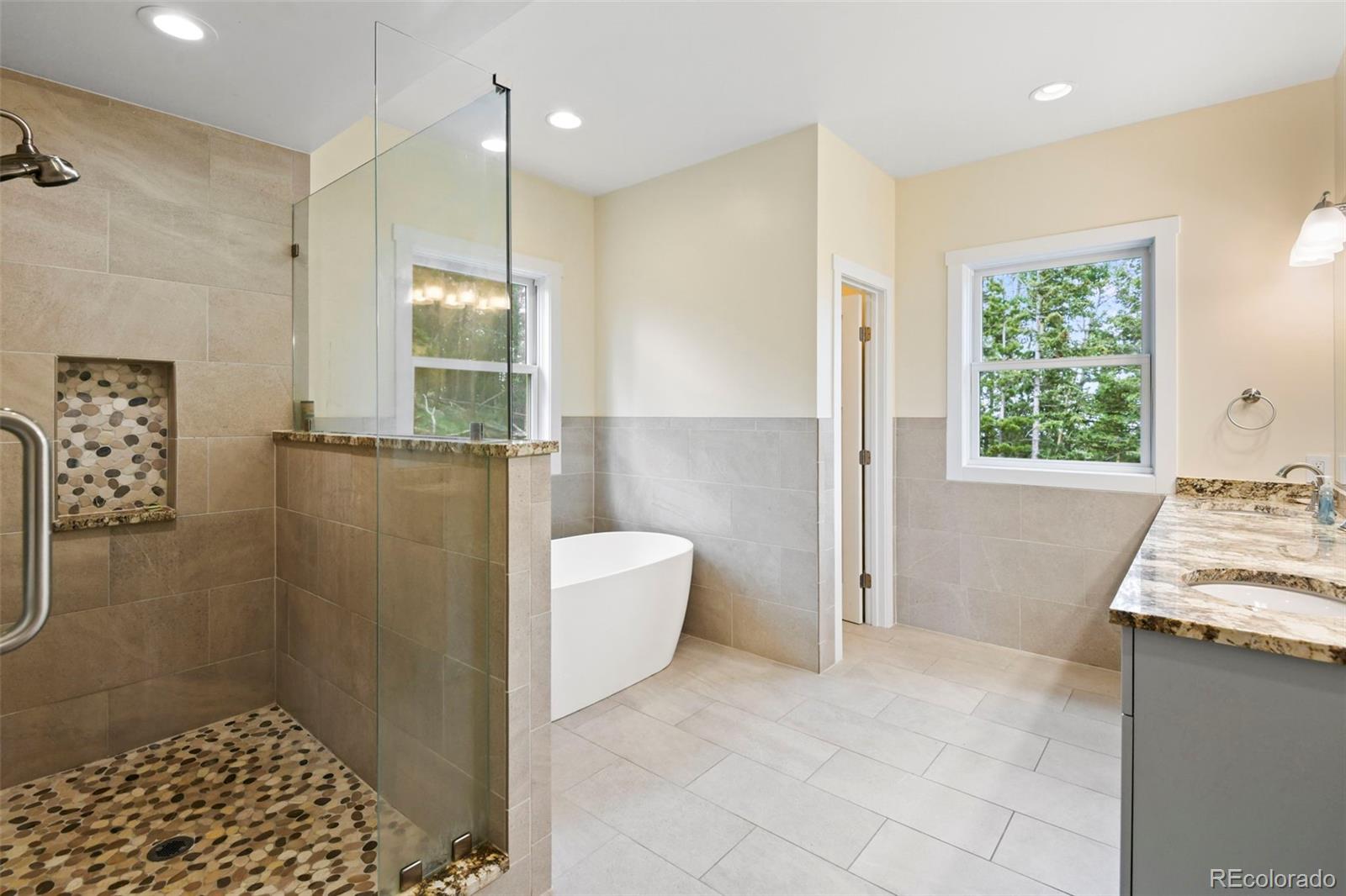 1555 Three Peaks Road Black Hawk, CO 80422 - Photo 44 of 50 a bathroom with a granite countertop sink a toilet and shower