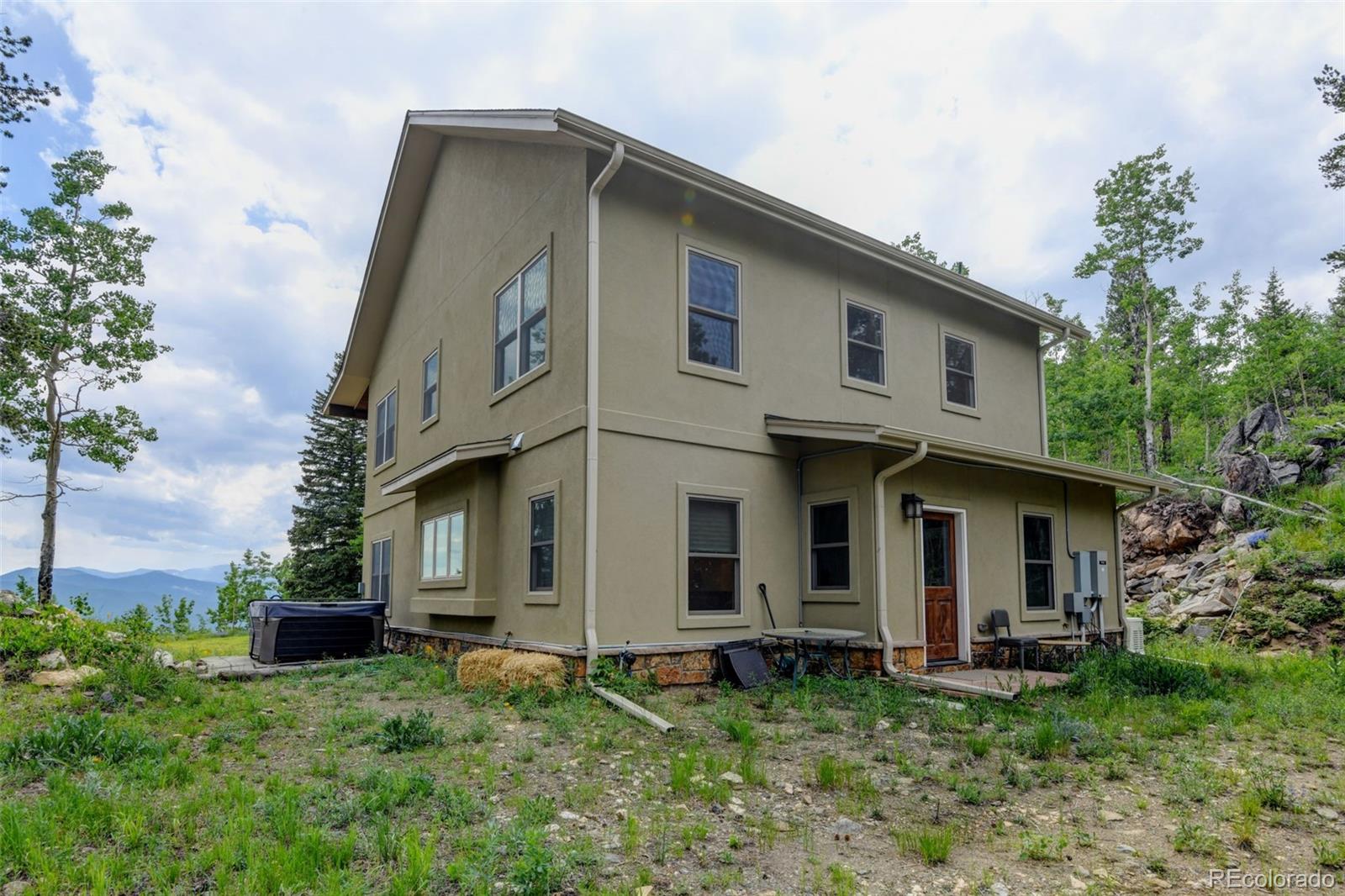 1555 Three Peaks Road Black Hawk, CO 80422 - Photo 49 of 50 a front view of a house with a garden