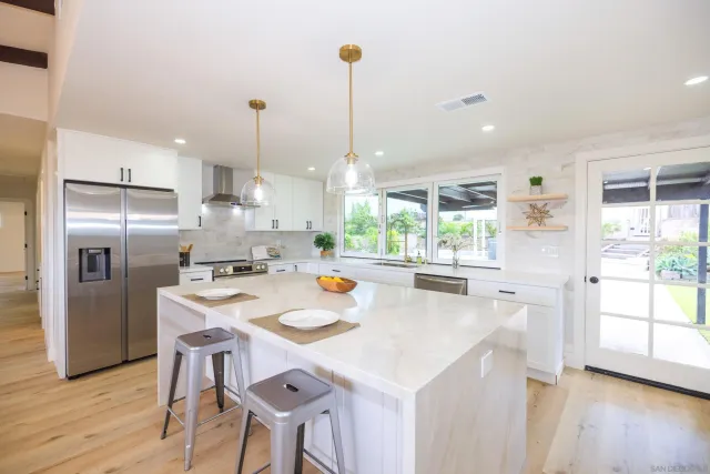 a large kitchen with a large window and stainless steel appliances
