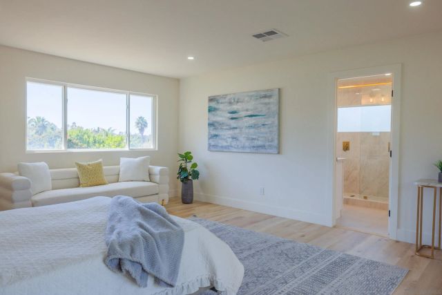 a bedroom with a bed cabinets and a window