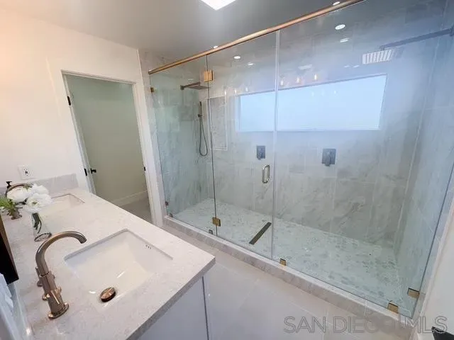 a bathroom with a double vanity sink mirror and shower