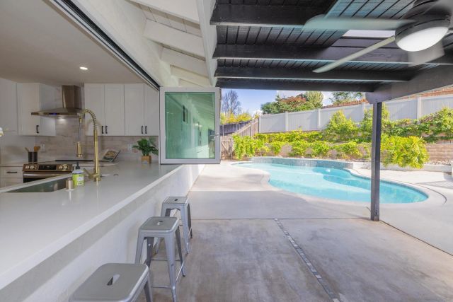 a view of house with swimming pool and a yard