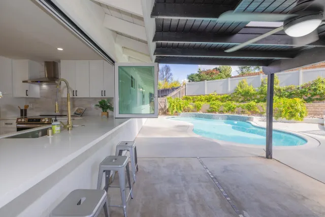 a view of house with swimming pool and a yard