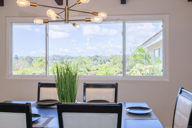 a view of a dining room and livingroom with furniture wooden floor a chandelier