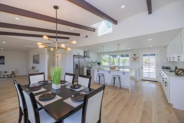 a kitchen with stainless steel appliances granite countertop a table chairs stove microwave and cabinets