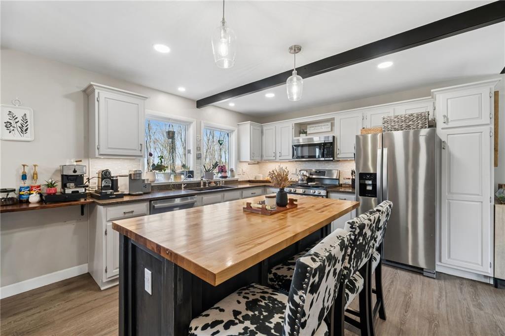 2187 Elizabeth Court Export, PA 15632 - Photo 11 of 43 a kitchen with granite countertop a table chairs microwave and refrigerator