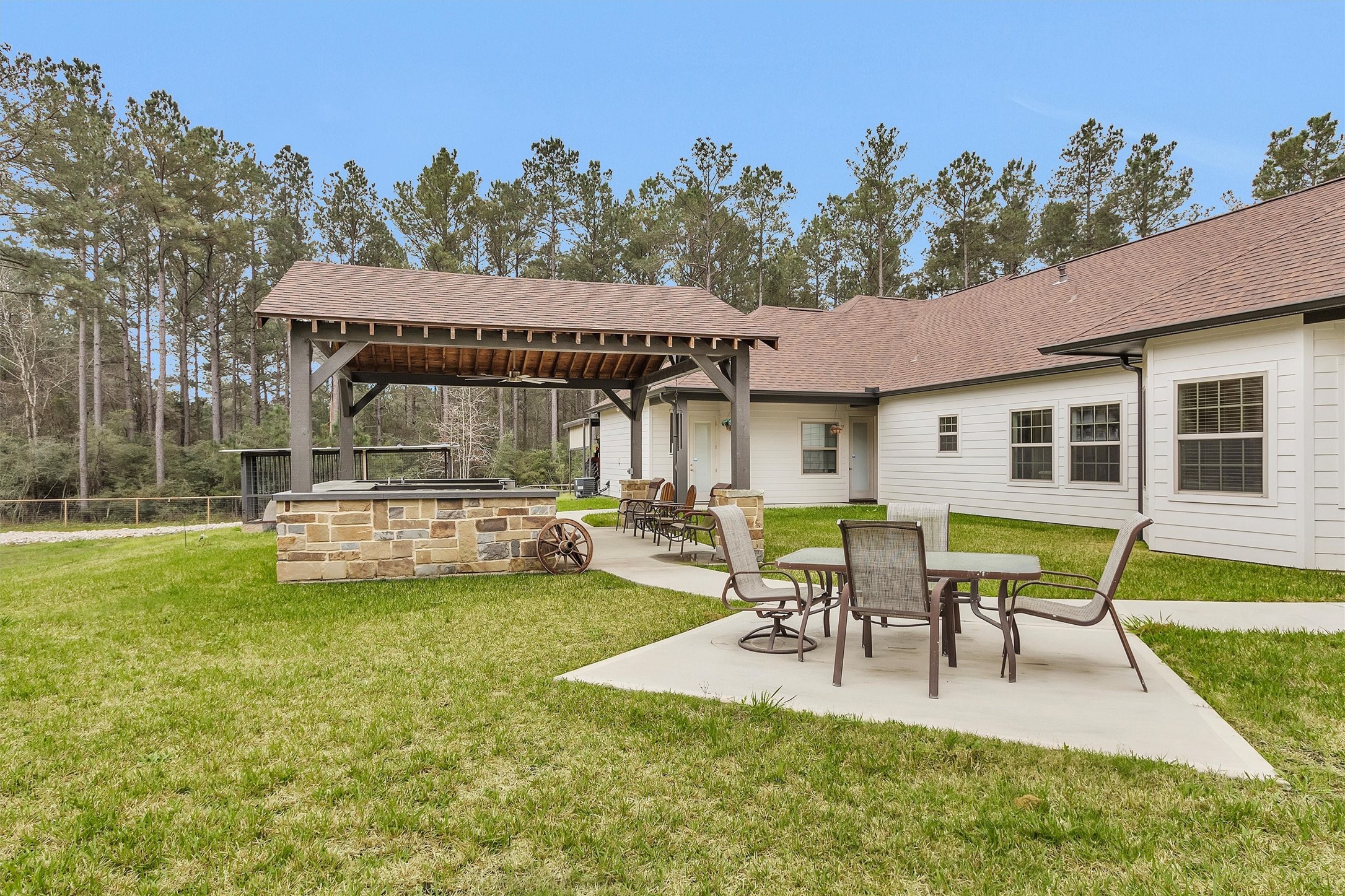 264 Grey Feather Road Huntsville, TX 77340 - Photo 26 of 31 Outdoor kitchen and bar area inside the pavilion overlooking the acreage. Back patio dining area with views of the backyard.
