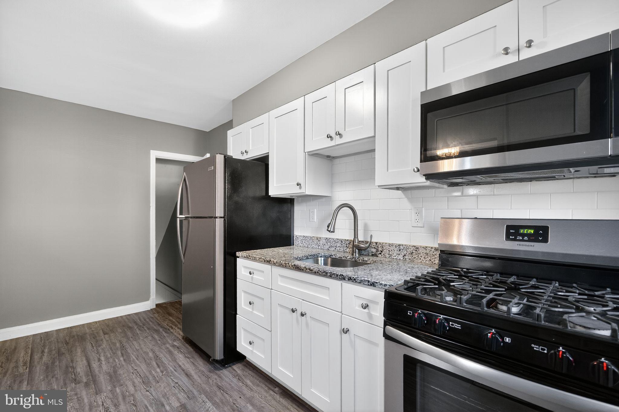 901 Kevin Road Baltimore, MD 21229 - Photo 20 of 31 a kitchen with stainless steel appliances a stove a microwave a sink and cabinets