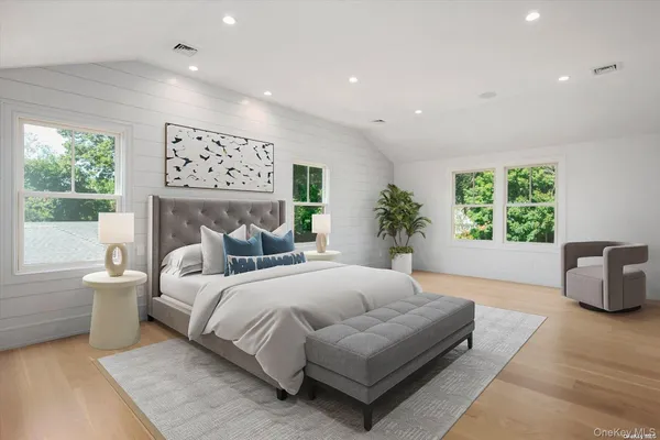 a spacious bedroom with a large bed couch and a large window