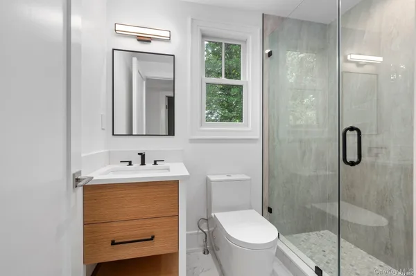 a bathroom with a toilet sink vanity and mirror