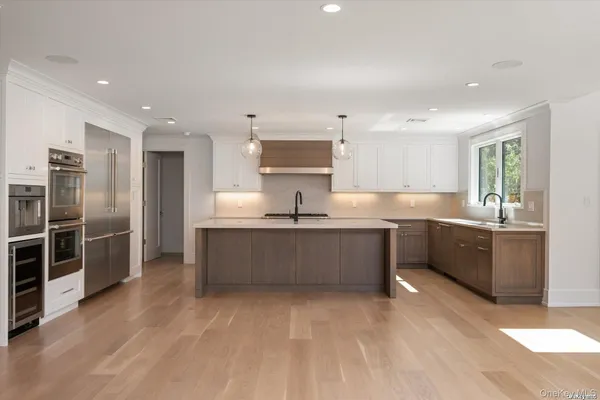 a large kitchen with stainless steel appliances kitchen island granite countertop a sink and cabinets
