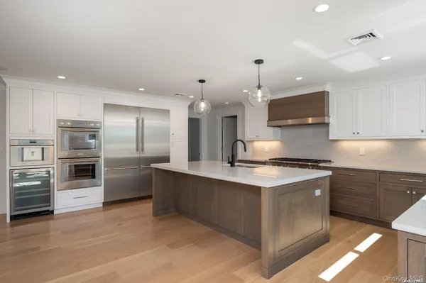 a open kitchen with stainless steel appliances granite countertop a stove top oven a sink and a refrigerator