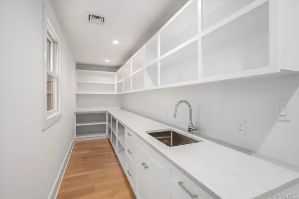 a kitchen with white cabinets and sink