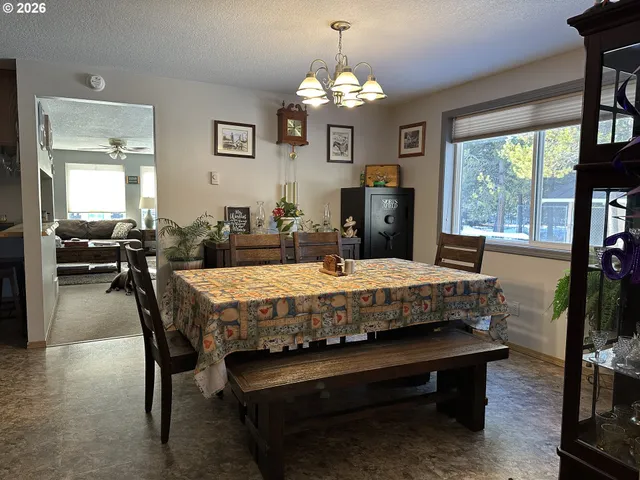 a living room with a table chairs and a chandelier