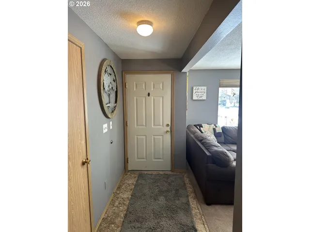 a hall way with furniture a mirror and a window