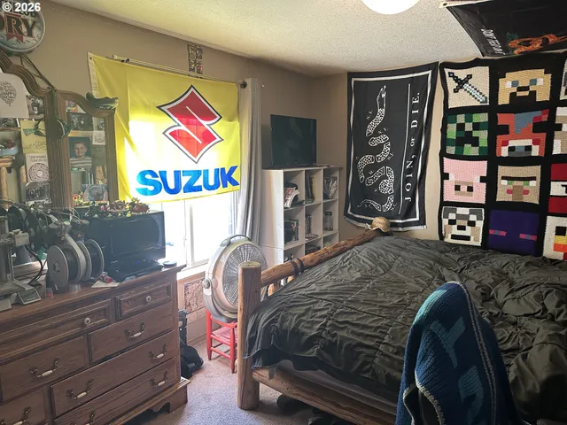 a bedroom with a bed and dresser with it