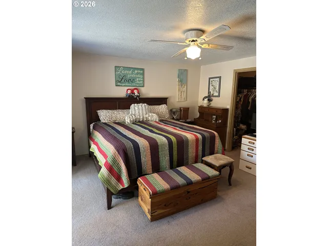 a spacious bedroom with a bed and a ceiling fan