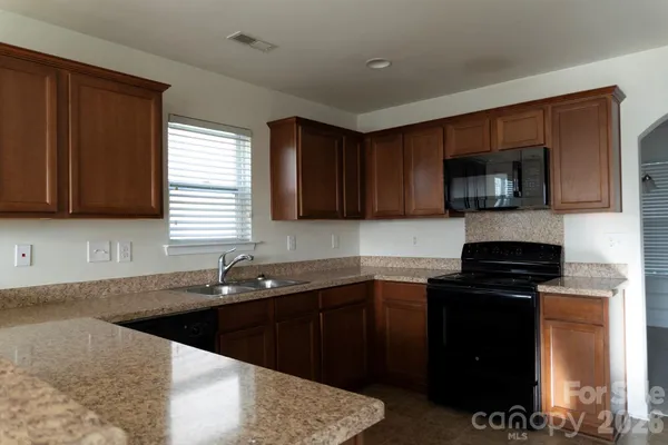a kitchen with a sink stove top oven and cabinets