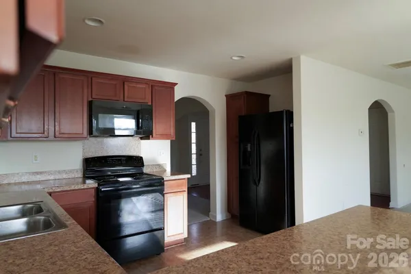 a kitchen with a refrigerator and a stove top oven