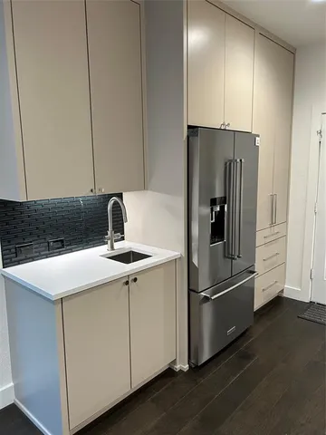 a kitchen with a refrigerator sink and cabinets