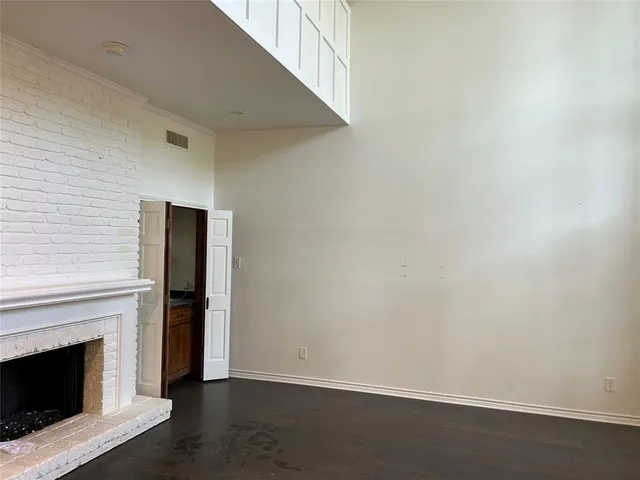 a view of empty room with wooden floor and fireplace