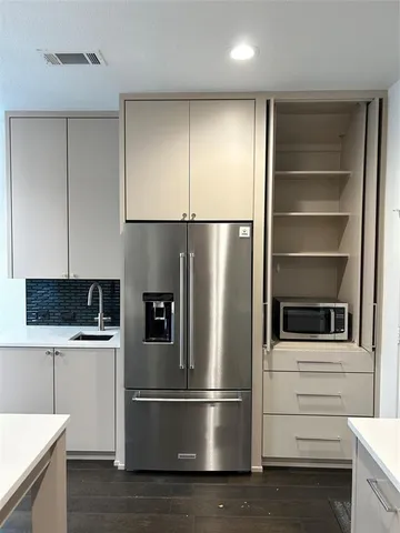 a kitchen with stainless steel appliances and wooden floor