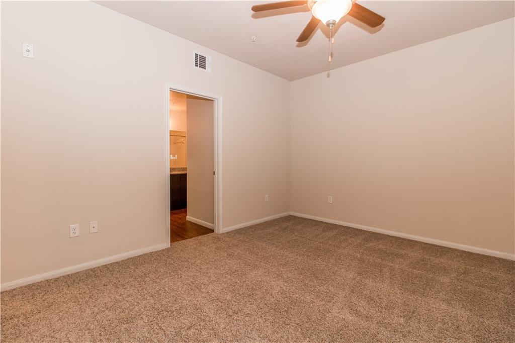 1401 East 4th Street, Unit 207 Austin, TX 78702 - Photo 4 of 9 an empty room with a ceiling fan and carpet