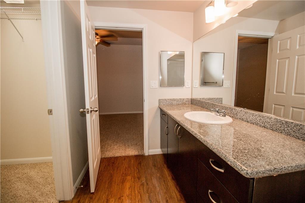 1401 East 4th Street, Unit 207 Austin, TX 78702 - Photo 5 of 9 a bathroom with a granite countertop sink and a mirror