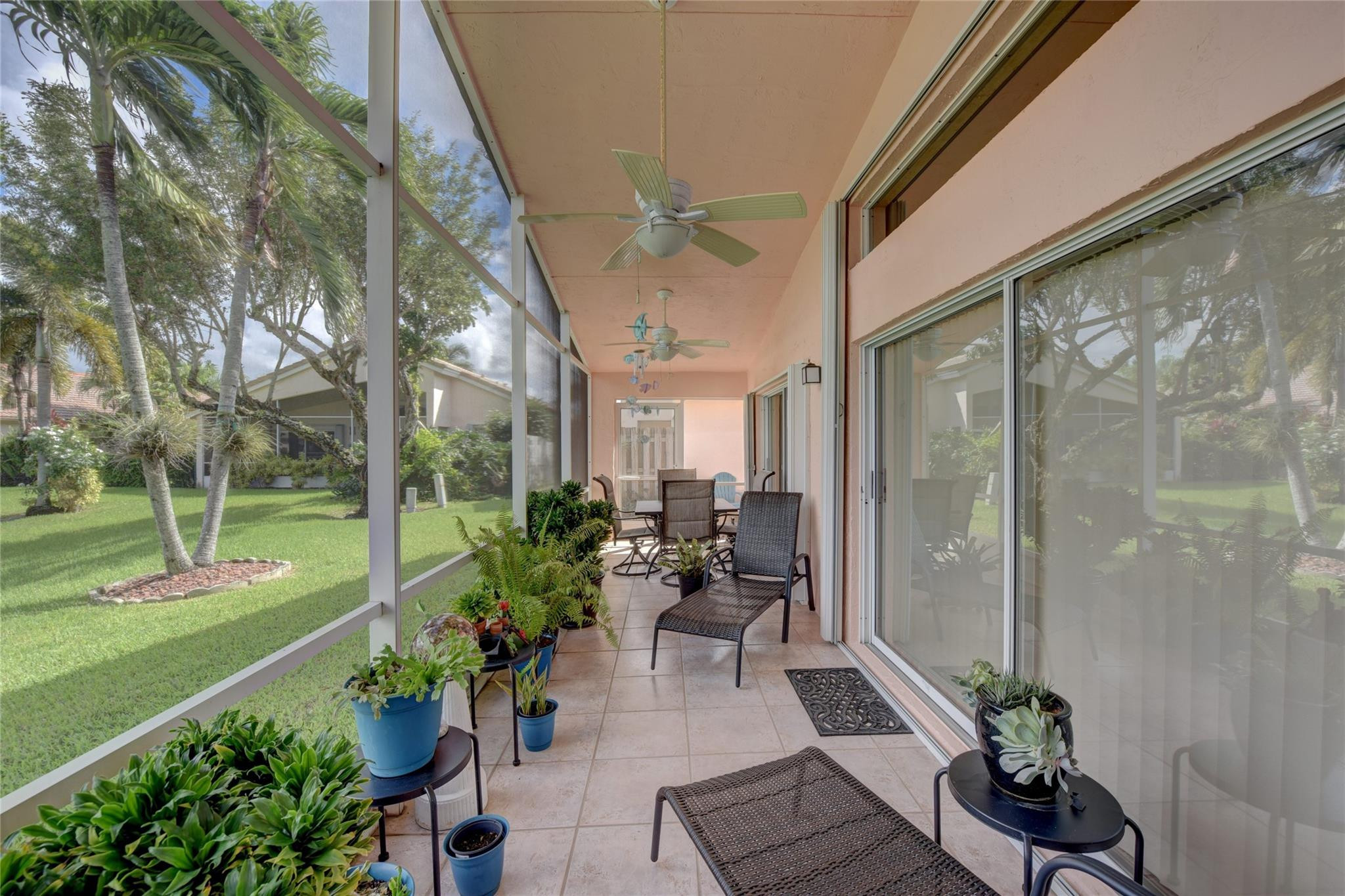 22918 Sterling Lakes Drive Boca Raton, FL 33433 - Photo 11 of 57 a view of a patio with couches table and chairs and potted plants