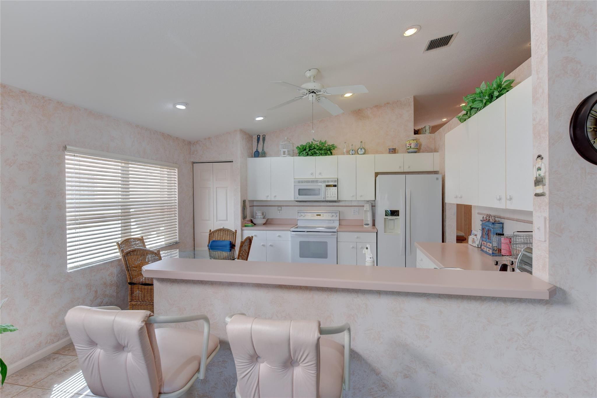22918 Sterling Lakes Drive Boca Raton, FL 33433 - Photo 24 of 57 a kitchen with stainless steel appliances kitchen island granite countertop a table chairs in it and a window