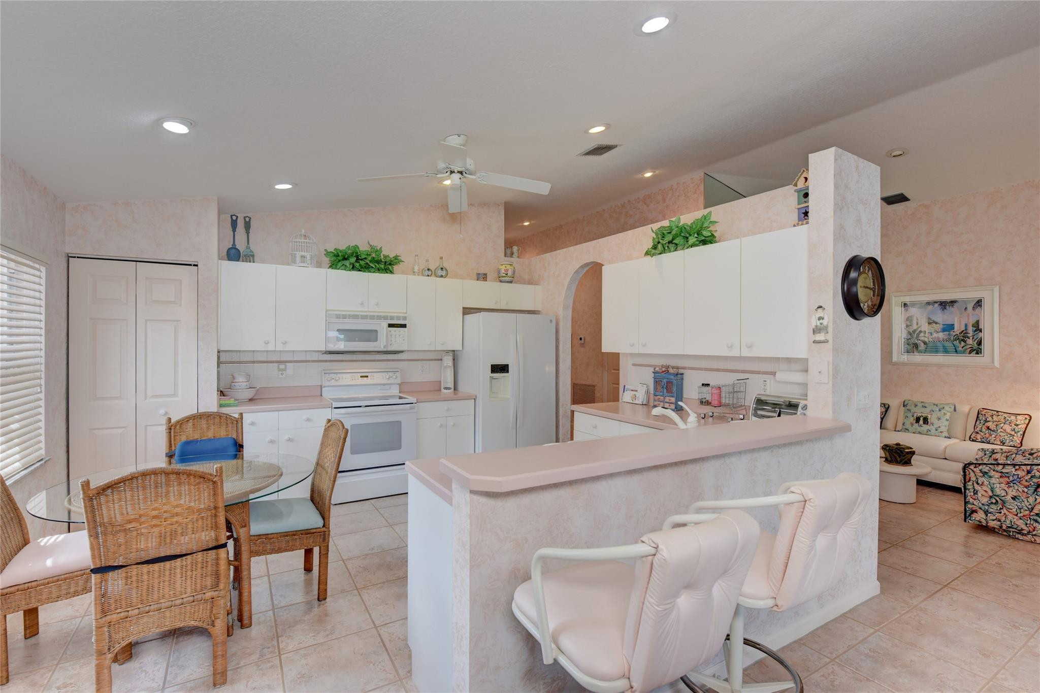 22918 Sterling Lakes Drive Boca Raton, FL 33433 - Photo 25 of 57 a kitchen with a dining table chairs and white appliances