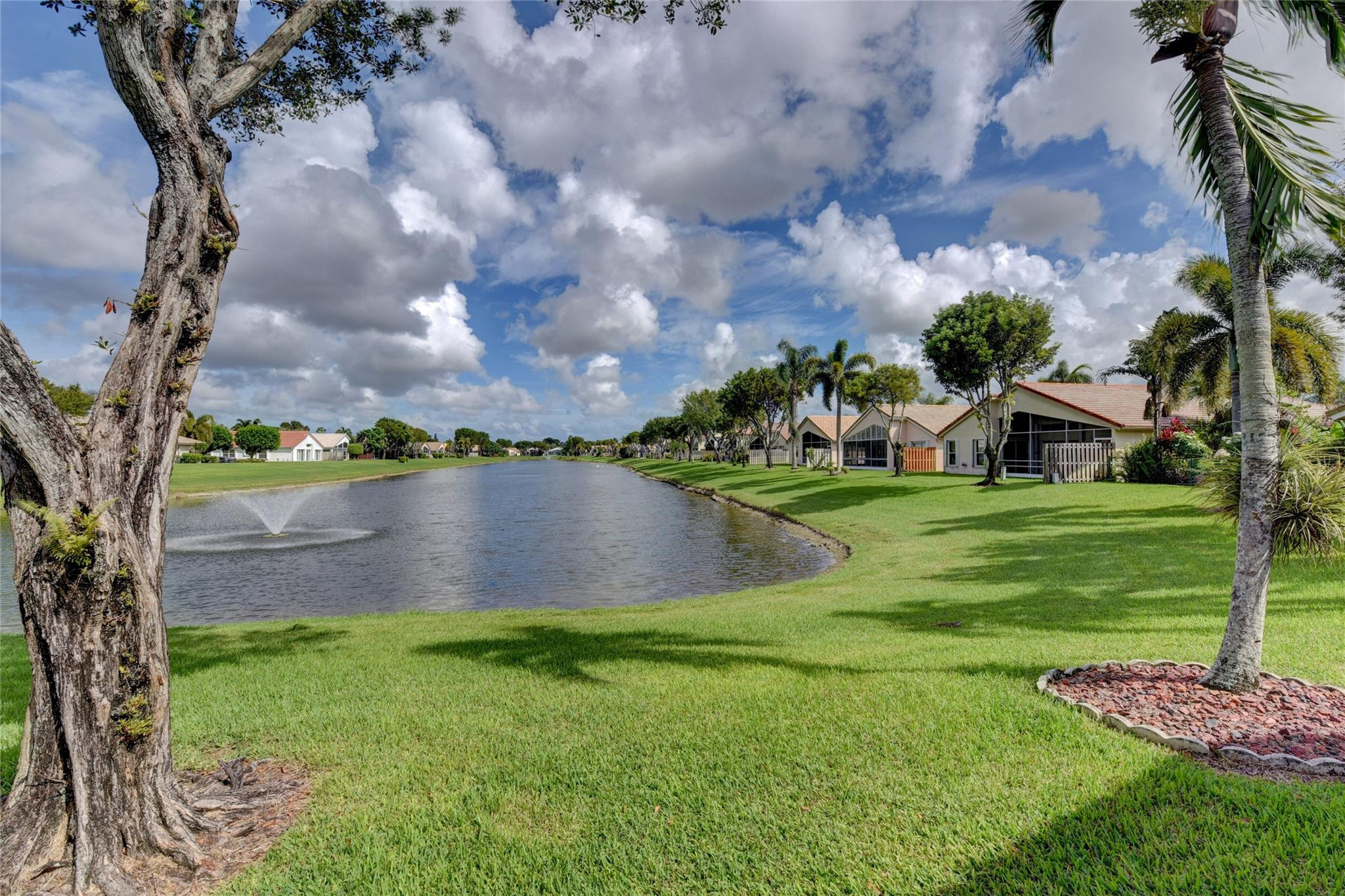 22918 Sterling Lakes Drive Boca Raton, FL 33433 - Photo 5 of 57 a view of a lake with a yard and large trees