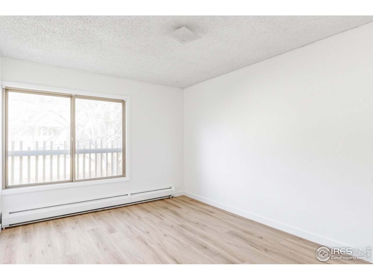2707 Valmont Road, Unit 205D Boulder, CO 80304 - Photo 7 of 18 an empty room with wooden floor and windows