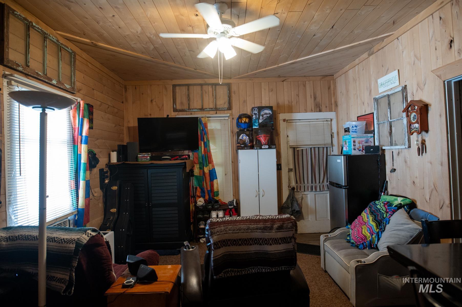 736 East Main Street Weiser, ID 83672 - Photo 31 of 33 Interior space featuring wood-paneled walls, a wood-finish ceiling with a ceiling fan, and a window with horizontal blinds