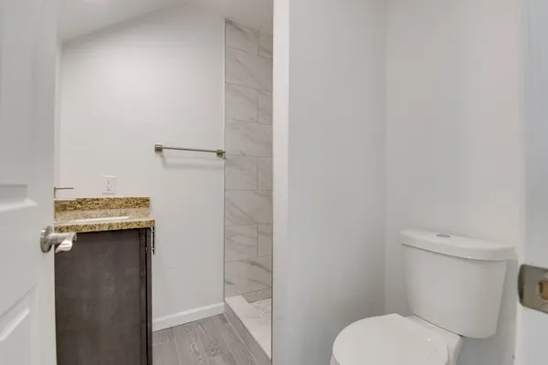 a white toilet sitting next to a shower