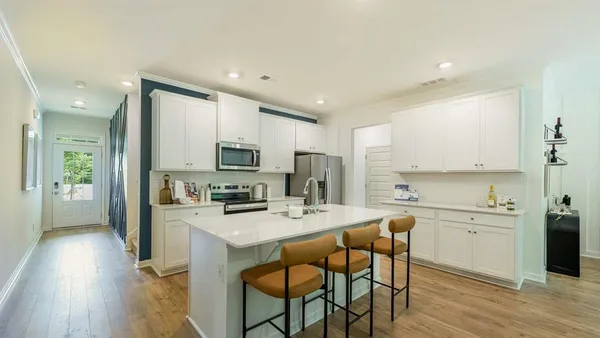 a kitchen with a sink a microwave a refrigerator and cabinets