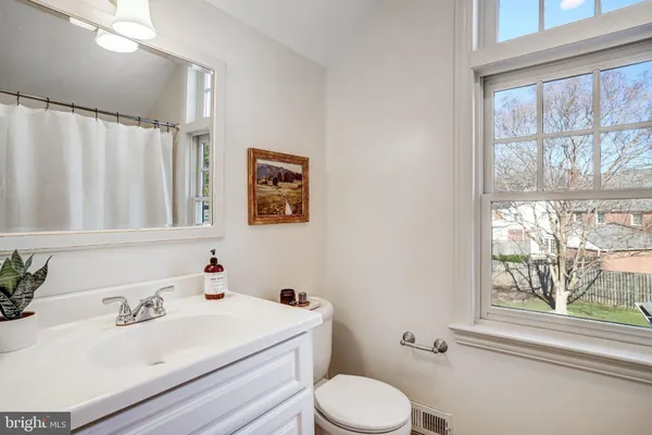 a bathroom with a sink toilet and window