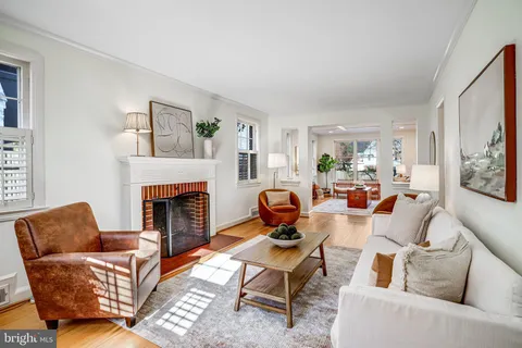 a living room with furniture a fireplace and a chandelier