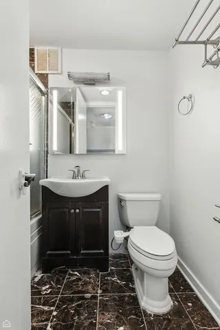 a bathroom with a sink a toilet and a mirror