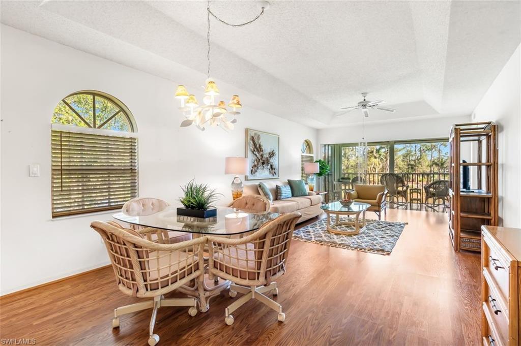 555 Augusta Boulevard, Unit 36 Naples, FL 34113 - Photo 13 of 25 a dining room with furniture a chandelier and wooden floor