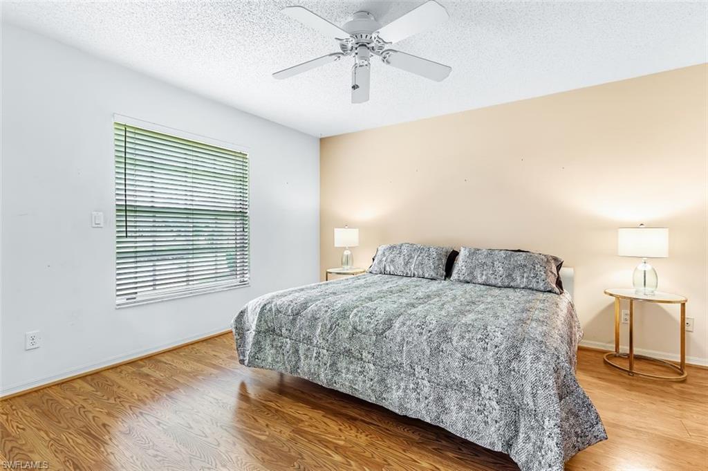 555 Augusta Boulevard, Unit 36 Naples, FL 34113 - Photo 19 of 25 a spacious bedroom with a bed a chandelier and a window