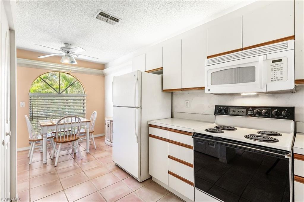 555 Augusta Boulevard, Unit 36 Naples, FL 34113 - Photo 4 of 25 a kitchen with stainless steel appliances granite countertop a stove a refrigerator and a microwave