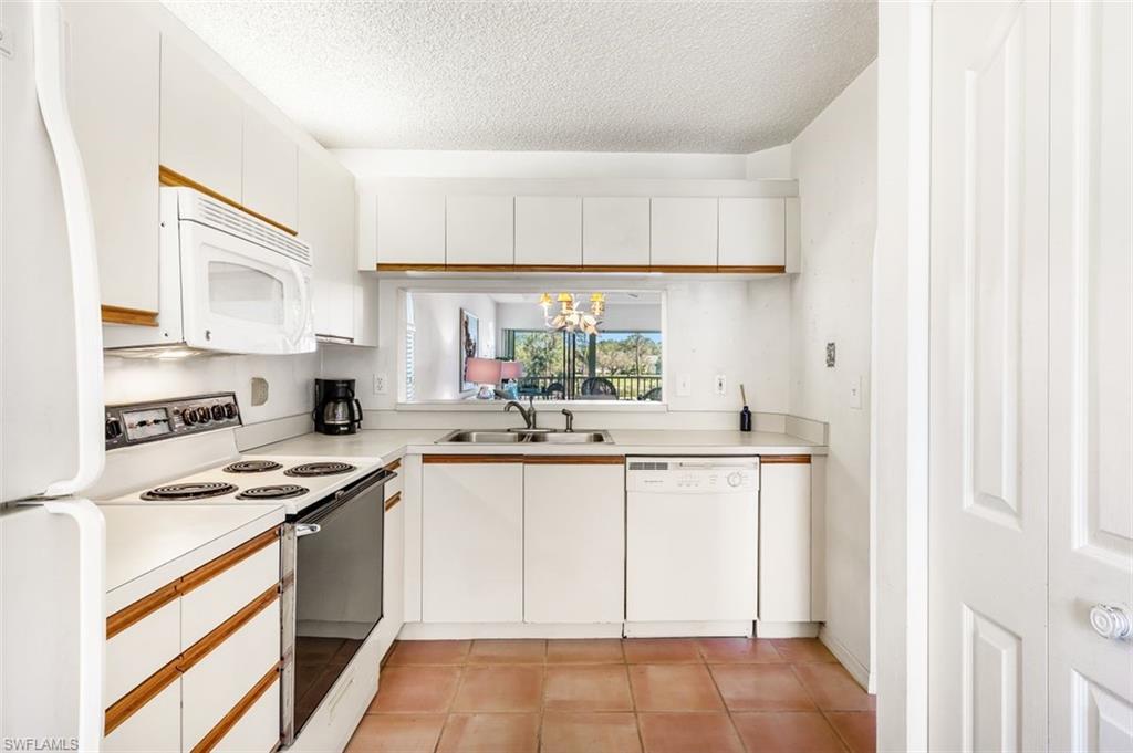 555 Augusta Boulevard, Unit 36 Naples, FL 34113 - Photo 8 of 25 a kitchen with stainless steel appliances a sink stove and white cabinets