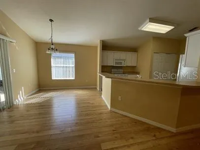 a kitchen with stainless steel appliances granite countertop a sink cabinets and wooden floor