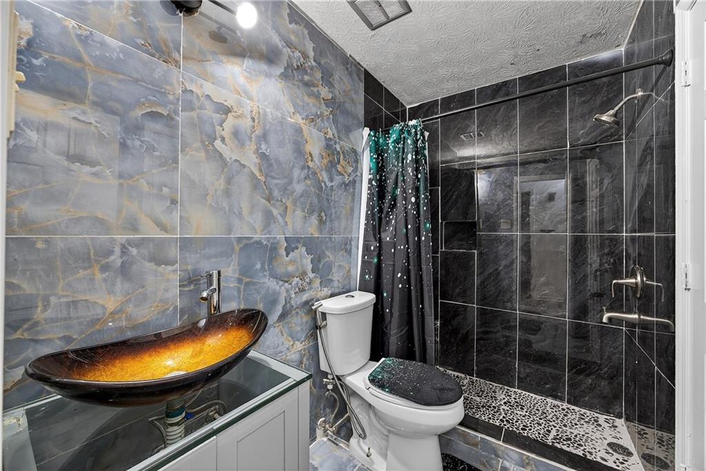 4673 Arrowhead Trail Southwest Lilburn, GA 30047 - Photo 13 of 28 a bathroom with a toilet and a shower