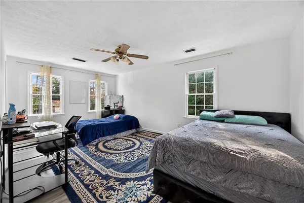 a bedroom with a bed and wooden floor