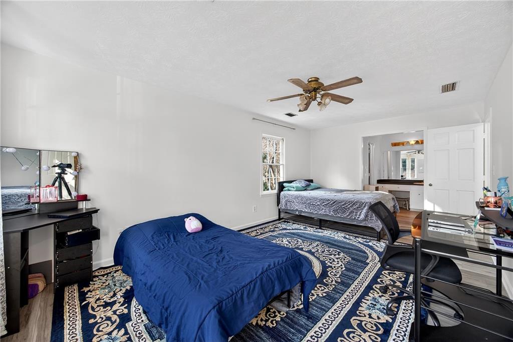 4673 Arrowhead Trail Southwest Lilburn, GA 30047 - Photo 16 of 28 a bed room with a bed and a chandelier